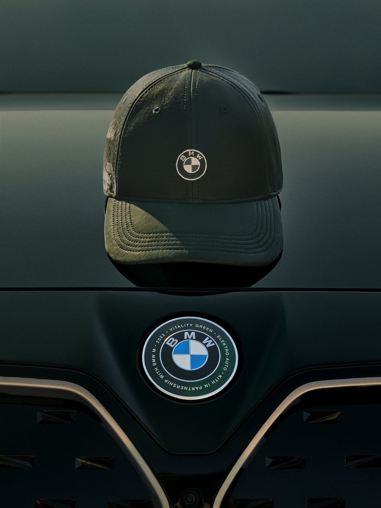 BMW 엠블럼이 놓인 차량 앞에 전시된 검은색 협업 캡