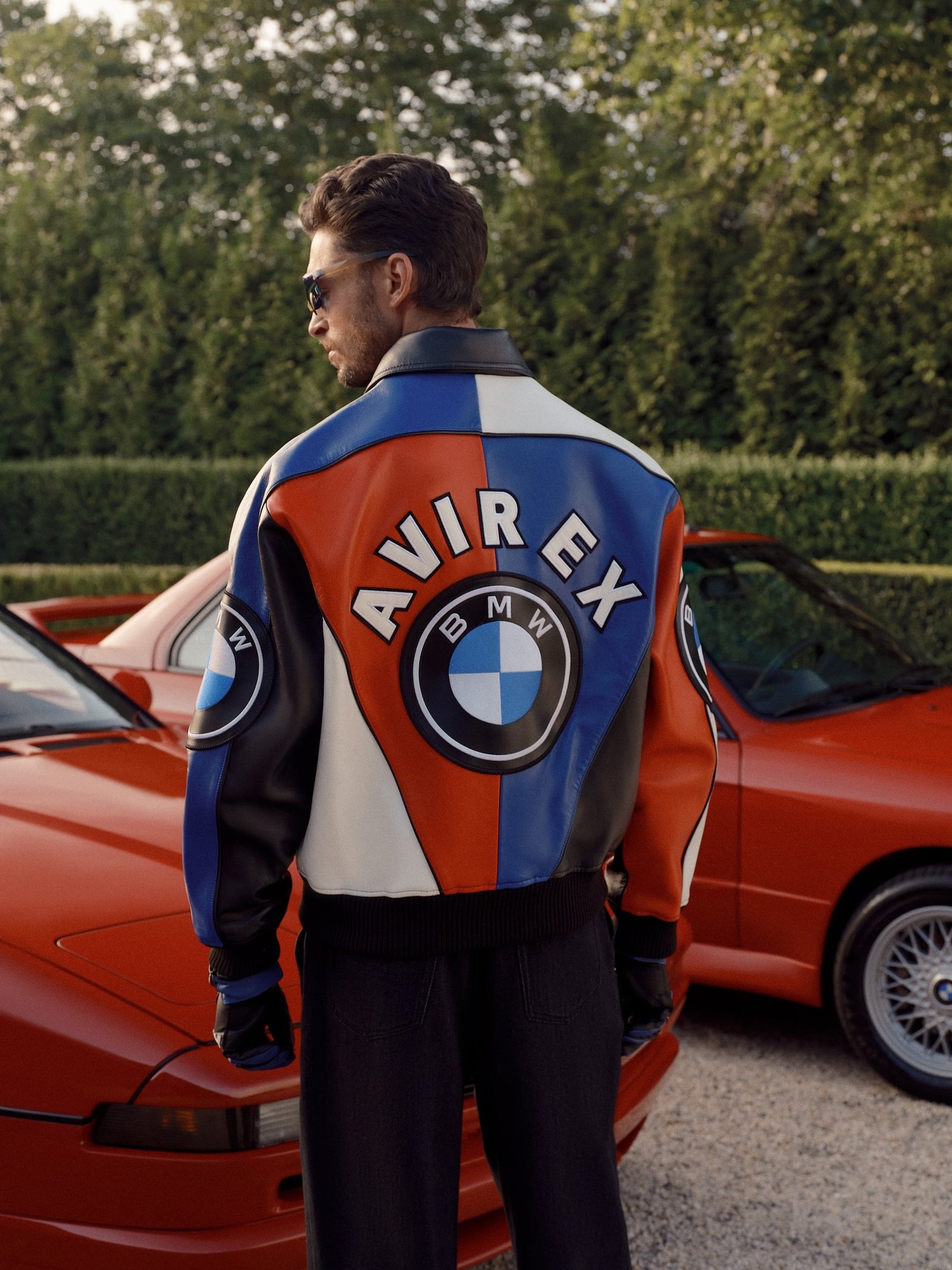 인카 오렌지 BMW 앞에서 AVIREX 협업 재킷을 착용한 모델