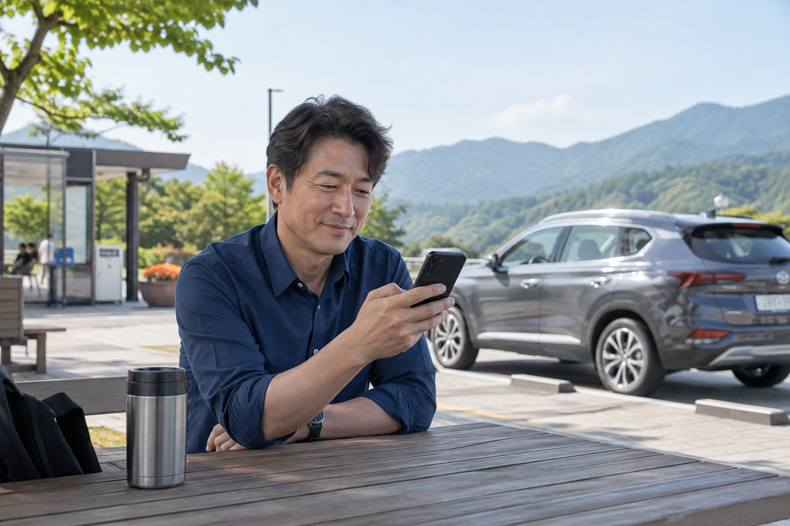 휴게 공간에서 휴대전화로 이동 일정을 확인하는 운전자